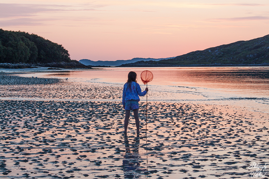 Girl with fishing net on the silver sands of Morar at sunset. Scottish Landscape Photography.